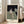 Distorted abstract seated figure surrounded by muted earth tones and shadows, evoking psychological depth and unease; framed modernist poster.