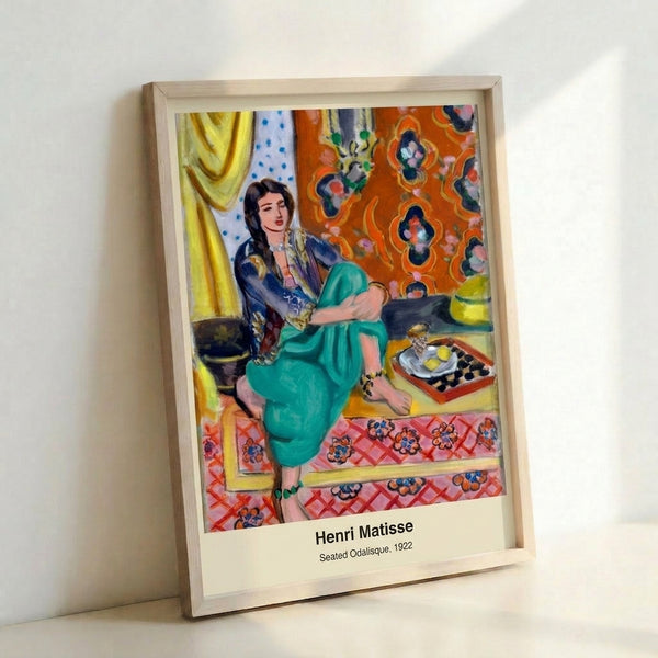 Contemporary wall art print depicting a seated odalisque in Matisse's characteristic minimalist style, using ochre, black, and cream against blue background.