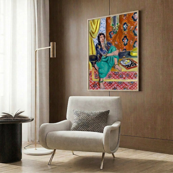 Wall-mounted art print of an odalisque in repose, dominated by warm ochre skin tones contrasted with cool blues and intricate decorative motifs in modernist style.