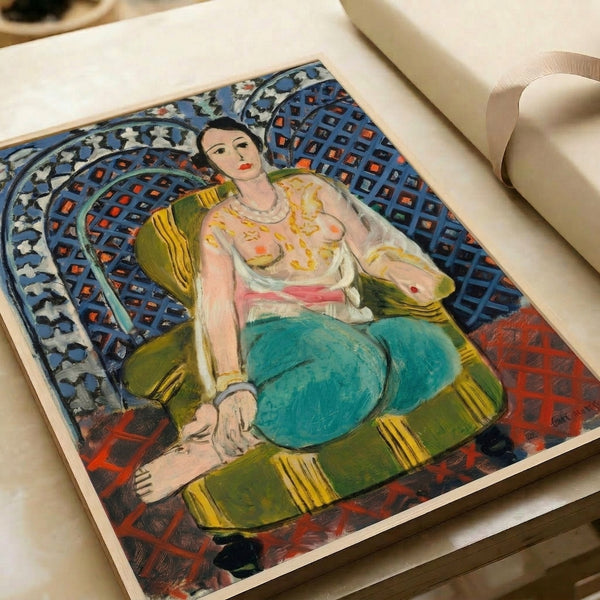 Colorful framed art depicting a relaxed odalisque surrounded by intricate decorative motifs in jewel tones and warm earth pigments.