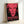Monumental silkscreen print featuring an abstract facial portrait in red and black, creating a haunting yet contemporary aesthetic in framed wall decor.