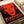 Contemporary pop art wall poster featuring a monumental abstract face rendered in bold silkscreen colors of red, black, and white with haunting presence.
