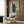 Moody expressionist print in earth tones featuring a blank-faced figure composition, hung as framed art that evokes introspection and the passage of time.