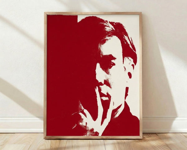 Bold pop art self-portrait in vibrant red and white tones, featuring simplified facial features in a modern, graphic style framed on a wall.