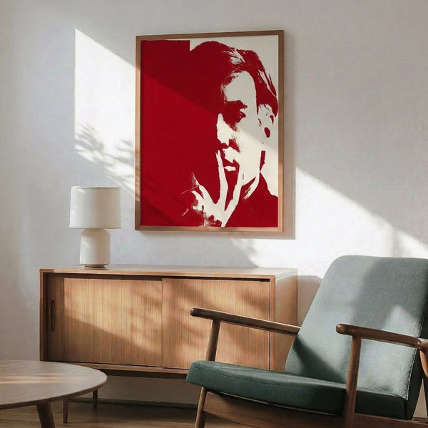 Vibrant pop art-inspired portrait artwork in red and white tones, featuring simplified abstracted facial elements and displayed as a framed poster.