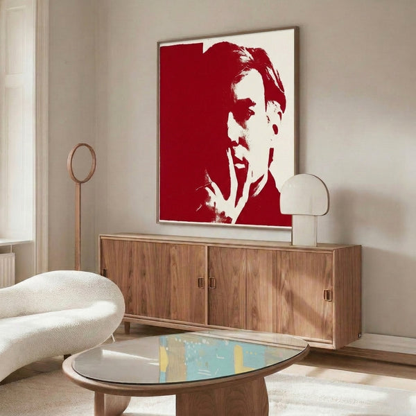 Contemporary self-portrait rendered in bold red and white color fields with graphic pop art influence, presented as a framed art print on the wall.