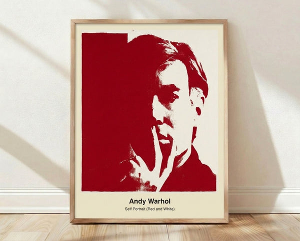 Bold pop art self-portrait in red, white, and black on a framed poster, featuring a stylized face with contemporary vibrancy.
