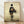 Minimalist woodblock-style poster of a woman in kimono walking away, rendered in cream, black, and muted ochre tones with an ethereal, contemplative mood.
