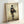 Wabi sabi inspired poster art showing a solitary figure in kimono viewed from behind, executed in minimalist style with mysterious black and ochre accents on neutral ground.