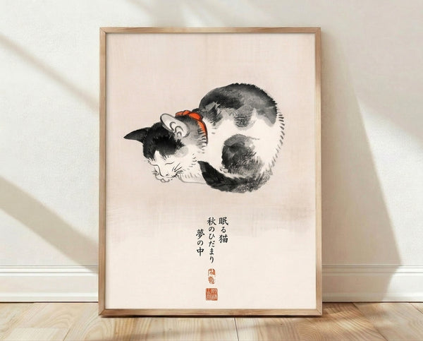 Framed Japanese woodblock-style art print of a sleeping cat in cream and black, with orange-red accents and calligraphy, evoking a peaceful, contemplative mood.