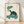 Contemplative sea turtle smoking a long pipe with curling smoke clouds, rendered in a minimalist Japanese woodblock style with teal, cream, and dark green tones.