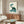Japandi wall poster depicting a zen turtle with pipe and swirling smoke clouds in soft cream and deep green hues, blending minimalist design with Japanese artistic traditions.