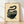 Japanese woodblock print of a coiled snake nestled in a teacup, rendered in cream, black, and dark teal with rust red accents, evoking a whimsical and curious mood.
