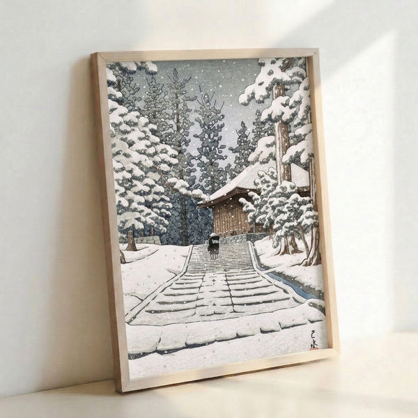 Framed Japanese woodblock art print featuring a snow temple with long staircase climbing through a misty forest landscape, dominated by cool whites, soft grays, and dark brown architectural elements.