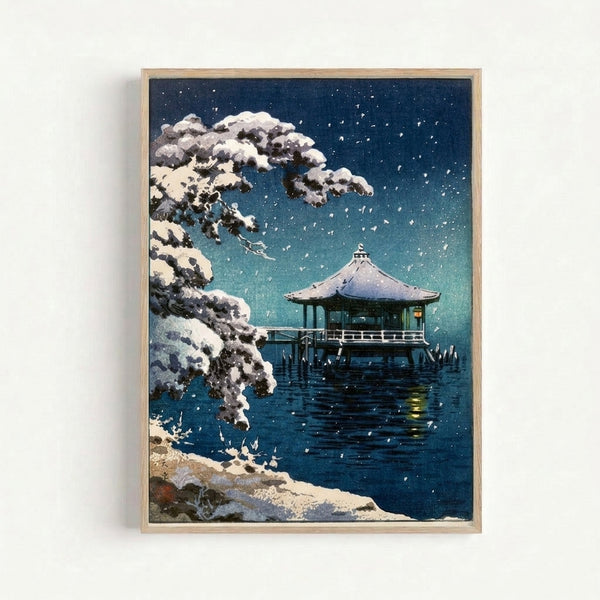 Winter landscape art print in Japandi style showing a tranquil pavilion with snow-laden trees and reflected stars, framed on a wall.