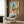 Warm bohemian wall art print with a western aesthetic showing a saguaro cactus, blanket-draped chair, guitar, and hat rendered in earthy burnt orange and turquoise hues.