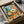 Nostalgic desert-themed poster print in retro style featuring a cactus, guitar, rustic chair, and hat arranged in muted sage green, turquoise, orange, and cream tones.