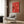 Framed kitchen art featuring playful, spirited ramen bowls in warm coral red tones with black accents and minimalist composition on cream backdrop.