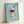 Simple line art illustration of stacked pottery teacups with warm color accents, displayed as a framed print on a wall.