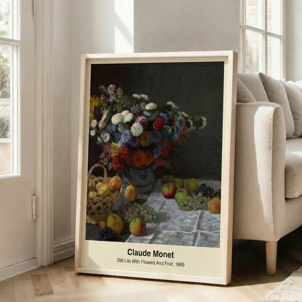 Framed art print of an Impressionist floral and fruit still life in muted pastels including cream, rose pink, and soft golden yellow on a subtle draped surface.