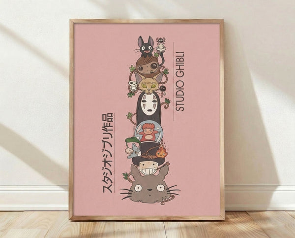 Whimsical Studio Ghibli character totem poster in rose pink, sage green, and charcoal gray, featuring stacked spirits and creatures in a playful anime art style framed on a wall.