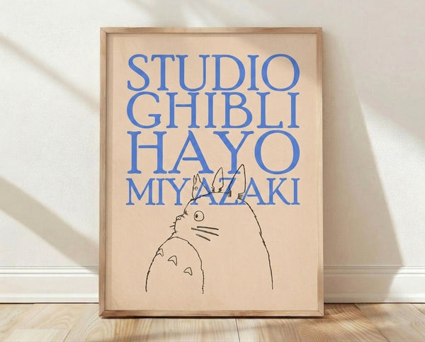 Minimalist line art poster of Totoro with typography in cream, blue, and black, framed on a wall as a whimsical Studio Ghibli tribute.