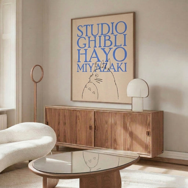 Whimsical line-art poster featuring the beloved Totoro creature with typographic design elements in a soft cream, blue, and black palette.