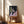 Fragmented human face in shades of brown, cream, and charcoal, displayed as a framed modern art poster with an introspective, brooding atmosphere.