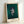 Framed contemporary art poster displaying an expressionistic figure in cream, black, and burnt orange with haunting, raw emotional intensity.