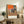 Contemporary abstract poster depicting the raw energy of a bullfight through agitated brushwork and a palette of warm browns, rust reds, and shadows.