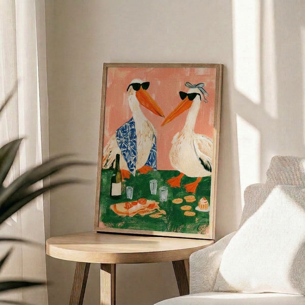 Coquette-style art print featuring a sophisticated pelican in sunglasses enjoying wine and treats at a playful picnic party, rendered in soft coral pink and navy blue hues.