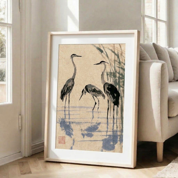 Three herons in traditional sumi-e technique with flowing ink wash, muted color palette of cream and soft blue-gray creating a calming, Zen-inspired wall art composition.