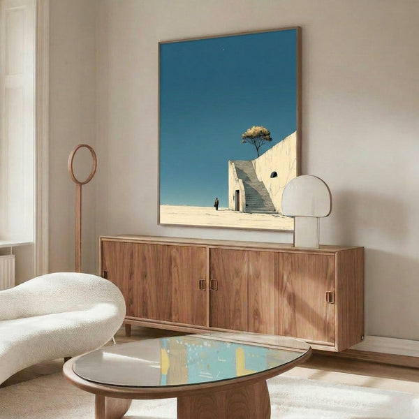 Contemplative framed poster with a lone figure on a desert stairway gazing at a crescent moon, featuring minimalist style and soft teal blue and sand beige colors.