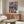 Contemporary wall art displaying whimsical goldfish intertwined with citrus fruits and decorative elements in cobalt, orange, cream, and gold tones, blending surreal and Art Nouveau aesthetics.