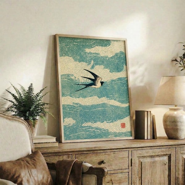 Japandi wall art showing a swallow in elegant motion over waves, combining Japanese woodblock printmaking with minimalist line drawing in muted greens, black, and off-white hues.