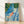 Watercolor painting of a serene swimmer floating in a deep blue pool surrounded by forest green and teal tropical leaves, rendered in a minimalist Japandi style with cream accents.