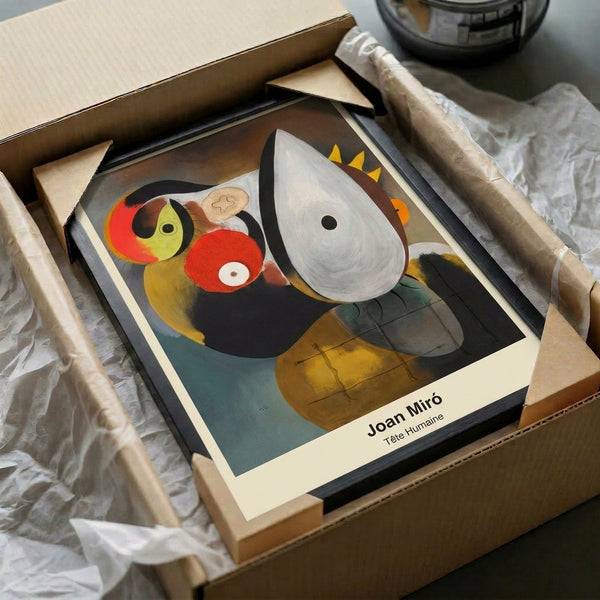 Dreamlike surreal face deconstructed into abstract shapes in rust, black, and cream, displayed as framed poster art.
