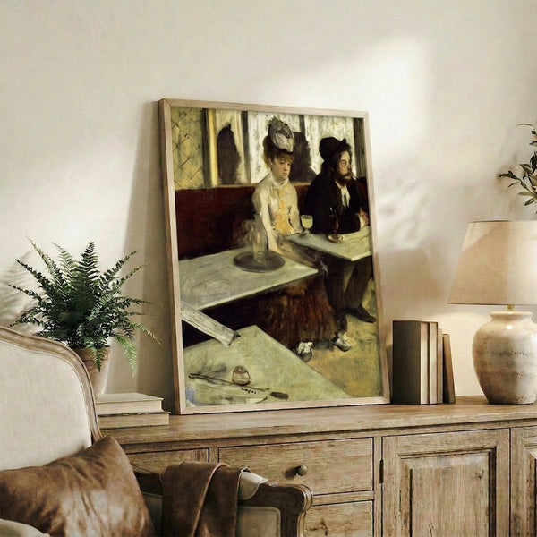 Framed reproduction poster featuring a contemplative drinker at a café, presented in subdued palette with atmospheric lighting characteristic of late 19th-century Parisian scenes.