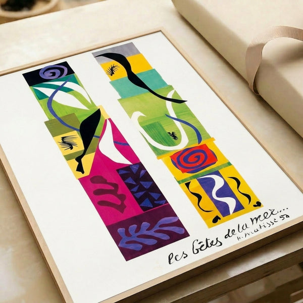 Wall-mounted art print with bold cutout shapes in complementary colors forming a playful interpretation of sea creatures and movement.