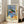 Wall art print in impressionist style depicting a blue vase as focal point amid scattered red apples and fruit on a table, rendered with nuanced balance of cool and warm hues.