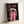 Dramatic retro poster showing a woman's haunting facial expression in vibrant hot pink and cream with stark black accents; contemporary pop art style wall art.