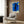 Modern abstract wall print inspired by the Icarus myth, showing a stylized figure in shades of royal blue, black, red, and yellow creating a contemplative, dreamlike scene.
