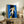 Modern wall poster with abstract interpretation of a falling figure rendered in striking reds, blues, and neutral tones using collage-inspired artistic technique.
