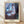 Framed expressionist poster depicting a melancholic young woman gazing from a window at night, rendered in muted browns, violets, and blues with shadowy atmospheric tones.