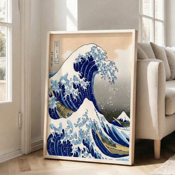 Hokusai's celebrated wave composition in deep indigo with pale blue sky and cream accents, featuring a mountain silhouette and small boat, framed as decorative artwork.