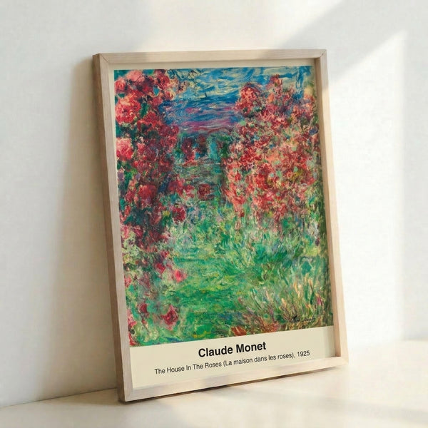 Monet-inspired wall art depicting a house amid flowering roses with loose brushwork in rose pink, soft green, and golden yellow hues.