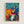 Framed art print showcasing a dynamic musical scene with stylized human figures dancing and playing instruments in warm and cool hues, evoking a cheerful, harmonious mood.