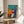 Framed abstract artwork depicting people in motion with musical instruments, composed of bold color blocks and organic shapes that convey rhythm, joy, and creative expression.