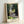 Framed Impressionist poster of Parc Monceau with soft green leaves and warm beige light, evoking a contemplative moment in nature through gentle brushwork.