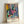 Minimalist floral poster art displaying blooming peonies in pink and blue hues with organic green foliage, contemporary abstract composition.